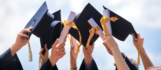 graduants raising their hats and certificates as if to say cheers for graduating.